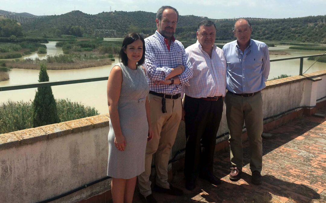 Los asistentes al encuentro con el embalse de Cordobilla al fondo